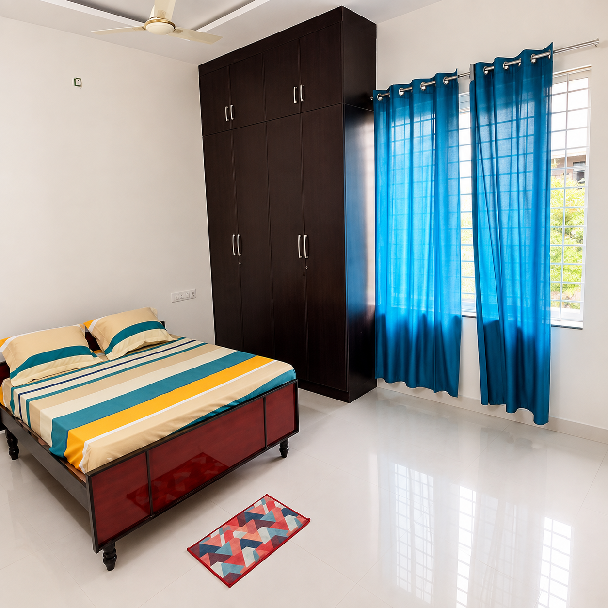 Modern bedroom, stylish bedroom interior, spacious bedroom, contemporary bedroom, bright bedroom, clean bedroom design, cozy bedroom, apartment bedroom, residential bedroom, master bedroom, comfortable bed, double bed, wooden bed frame, striped bedsheet, colorful bedding, blue curtains, turquoise curtains, yellow bedding, dark wood wardrobe, large wardrobe, built-in storage, bedroom storage, ample storage space, glossy tiled floor, white floor tiles, large windows, natural light, ventilated bedroom, ceiling fan, false ceiling, modern ceiling design, minimalist bedroom, organized bedroom, functional bedroom, peaceful bedroom, airy bedroom, elegant bedroom, practical bedroom layout, urban home interior, apartment living, rental bedroom, student-friendly bedroom, student accommodation, student living space, business professional accommodation, professional-friendly bedroom, comfortable rental home, working professional bedroom, relaxing bedroom space, modern home design, real estate bedroom.